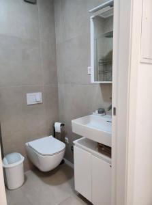 a white bathroom with a toilet and a sink at Apartment Bety, Stomorska, Solta in Stomorska