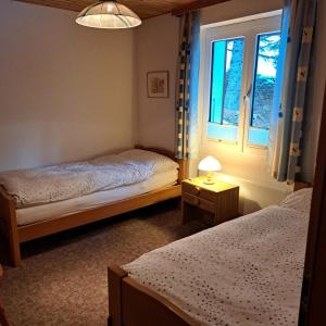 1 dormitorio con 2 camas y ventana en Chalet Waldrand en Inden