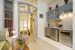 a kitchen with stainless steel appliances and a glass door at LA MAISON VERTE SETE in Sète