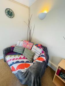 un sofá con almohadas en una habitación en 22B, en Wellingborough