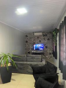 un salon avec un canapé et une télévision sur un mur dans l'établissement Residencia Canterville, à Olímpia
