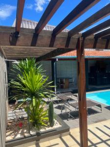 un patio avec une pergola en bois et une piscine dans l'établissement Residencia Canterville, à Olímpia