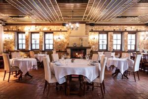 a dining room with tables and chairs and a fireplace at Ktima Bellou in Ágios Dimítrios