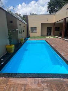 a large blue swimming pool in the backyard of a house at Casa em ALTER DO CHÃO 3 QUARTOS in Alter do Chao