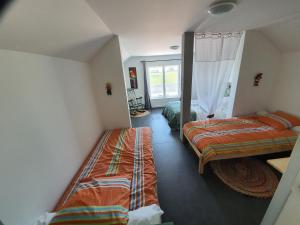 1 dormitorio con 2 camas y ventana en LE FER A CHEVAL en Les Bizots
