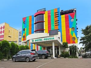 a hotel lobby with cars parked in a parking lot at Super OYO Townhouse OAK Hotel Fiducia Serpong in Serpong