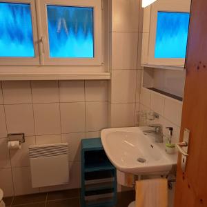 a bathroom with a sink and two windows at Chalet Waldrand in Inden