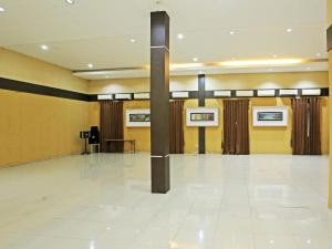 a large room with yellow walls and a white tile floor at Super OYO Townhouse OAK Hotel Fiducia Serpong in Serpong