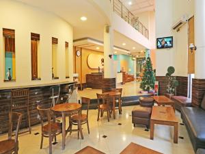 ein Restaurant mit Tischen und Stühlen und einem Weihnachtsbaum in der Unterkunft Super OYO Townhouse OAK Hotel Fiducia Serpong in Serpong