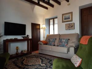 sala de estar con sofá y TV de pantalla plana en La Cata, en Aguilar de la Frontera
