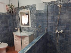 Aguilar de la FronteraにあるLa Cataの青いタイル張りのバスルーム(シンク、鏡付)