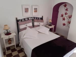 1 dormitorio con 1 cama grande y 2 mesas en La Cata, en Aguilar de la Frontera