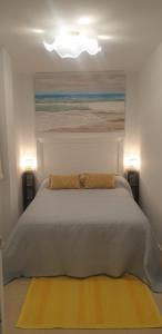 a bedroom with a bed with a painting and two lamps at Aldea Blanca Cute in Marbella