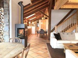 a living room with a fireplace and a table at Ferme Vauvray in Megève