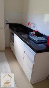 uma cozinha com um lavatório e uma bancada em Loft central Sant Helena Gramado Rs em Gramado