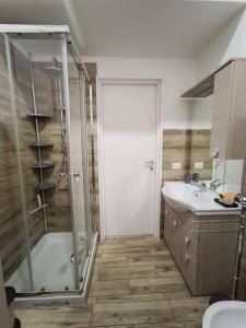 a bathroom with a glass shower and a sink at Casa No-Vi in Rome