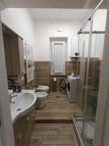 a bathroom with two toilets and a sink and a shower at Casa No-Vi in Rome