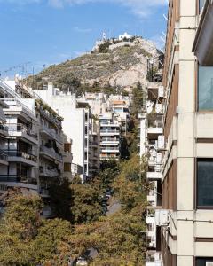 Eine Stadt mit einem Hügel im Hintergrund in der Unterkunft Kolonaki Luxury Residence in Athen
