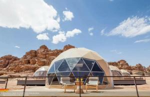 a dome tent with chairs in front of some rocks at Sultan Al_ wadi rum in Wadi Rum