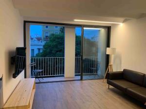 a living room with a couch and a large sliding glass door at L'Havana Xica in Vilanova i la Geltrú