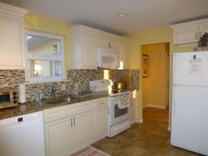 a kitchen with white cabinets and a white refrigerator at Red brick house in Chalfont