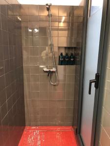 a shower with a red floor in a bathroom at L'Havana Xica in Vilanova i la Geltrú