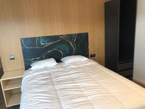 a large white bed with a painting on the headboard at L'Havana Xica in Vilanova i la Geltrú