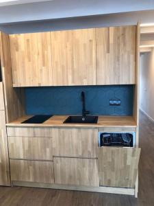 a kitchen with wooden cabinets and a sink at L'Havana Xica in Vilanova i la Geltrú