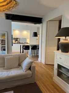 een woonkamer met een bank en een eetkamer bij Luxe et Charme - Le Carré Saint-Silain in Périgueux
