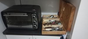 a kitchen counter with a microwave and a box of tools at Guesthouse Playa Chinchorro in Arica