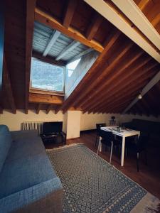 a room with a bed and a table in a attic at RL - Boutique Suites & Apartments in Bienno
