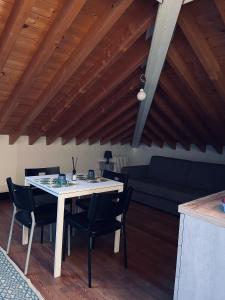 a table and chairs in a living room with wooden ceilings at RL - Boutique Suites & Apartments in Bienno