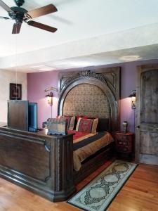 1 dormitorio con 1 cama grande y paredes moradas en Tuscan Manor en Eureka Springs