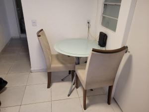 una mesa blanca y sillas con un teléfono. en Self Hostel, en São Paulo 11 fotos más