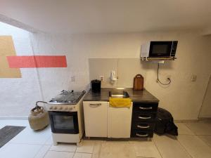 uma pequena cozinha com fogão e micro-ondas em Self Hostel em São Paulo