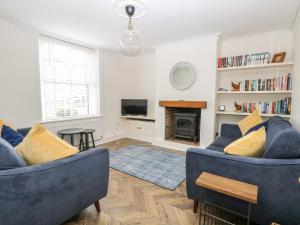 a living room with two blue couches and a fireplace at Springfield in Fakenham