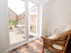 a room with a wicker chair and a patio at Springfield in Fakenham