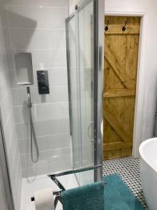 La salle de bains est pourvue d'une douche avec une porte en verre. dans l'établissement Coiners Rest, à Heptonstall