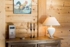 a table with a lamp on top of a wooden wall at Ferme Vauvray in Megève