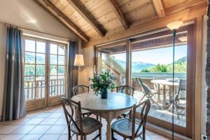 a dining room with a table and chairs and a balcony at Ferme Vauvray in Megève +17 photos