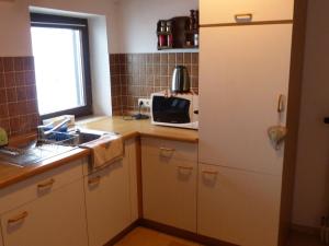 a small kitchen with a sink and a microwave at Pleasant Apartment in Zenting with Garden in Zenting