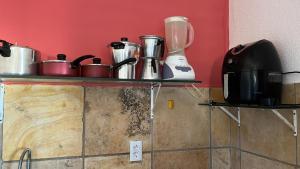 a counter with pots and pans and a blender at TAIBA - ONDAS DO MAR RESIDENCE Ap 212 - Rezende Temporada in São Gonçalo do Amarante