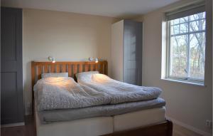 een bed in een slaapkamer met een raam bij Stunning Home In Ronneby With House Sea View in Ronneby