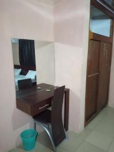 a desk with a mirror and a chair in a room at Greendale apartment and Lodge in Ibadan