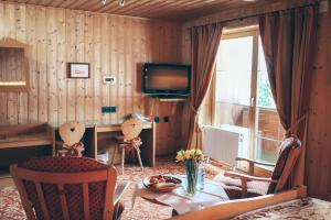 uma sala de estar com uma mesa e cadeiras e uma televisão em Landhotel zur Grenze em Isny im Allgäu