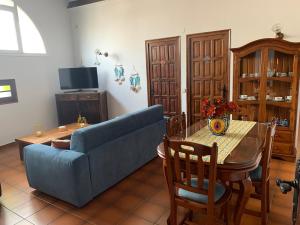 a living room with a blue couch and a table at Apartament Cal Negre in Vilassar de Mar