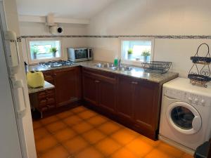 a kitchen with a sink and a washing machine at Apartament Cal Negre in Vilassar de Mar