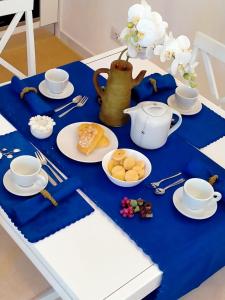 una mesa azul con platos de comida y una tetera en Villetta con Piscina e Campo da Tennis condominiale en Villasimius