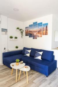 ein blaues Sofa im Wohnzimmer mit einem Tisch in der Unterkunft Enjoy La Carihuela Beach at 4 Min.Terrace & Pool. in Torremolinos
