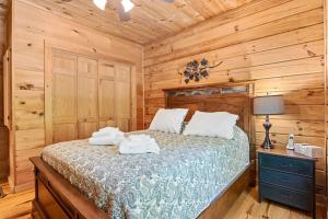 - une chambre avec un lit dans une cabane en rondins dans l'établissement Wolf Laurel - Dine/Golf/Swim/Tennis/Hike/Hot-tub, à Swiss